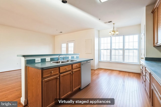 kitchen with dishwasher, sink, light hardwood / wood-style flooring, an island with sink, and a chandelier