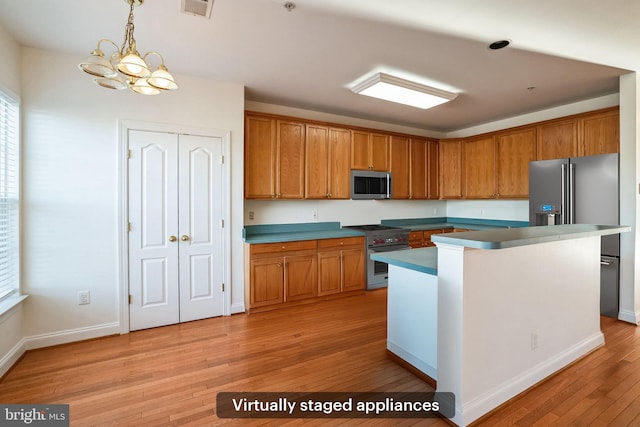 kitchen featuring pendant lighting, light hardwood / wood-style flooring, high quality appliances, a notable chandelier, and a center island