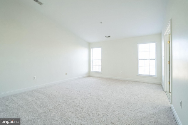 carpeted empty room with vaulted ceiling