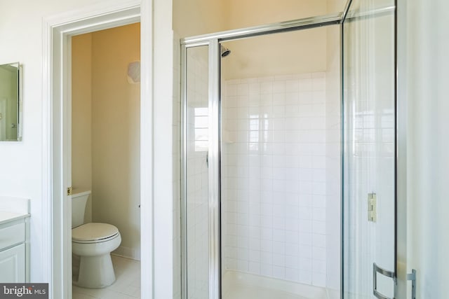 bathroom featuring tile patterned floors, vanity, toilet, and walk in shower