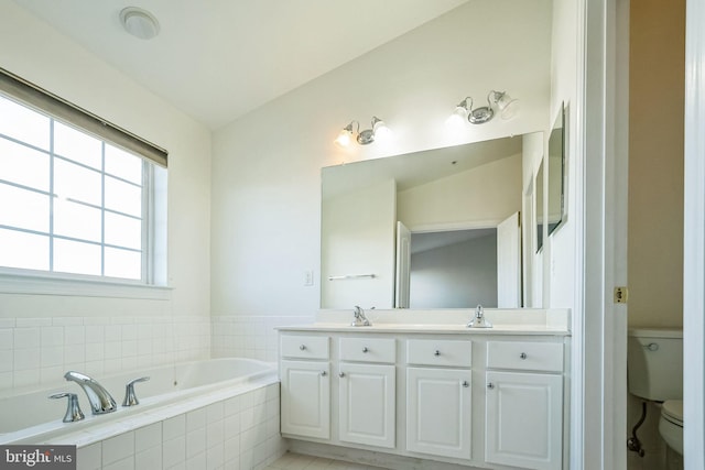 bathroom featuring vanity, tile patterned flooring, tiled bath, toilet, and lofted ceiling