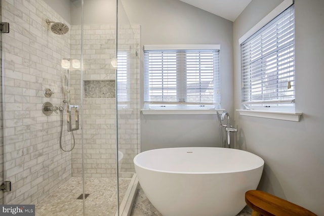 bathroom featuring independent shower and bath and lofted ceiling