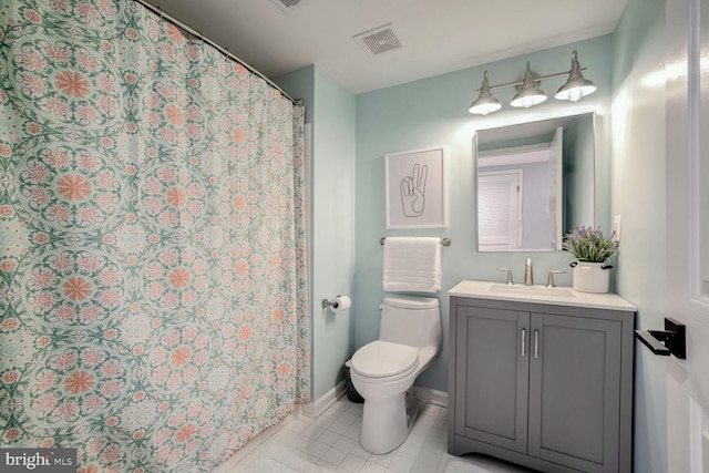 bathroom featuring tile patterned floors, curtained shower, vanity, and toilet