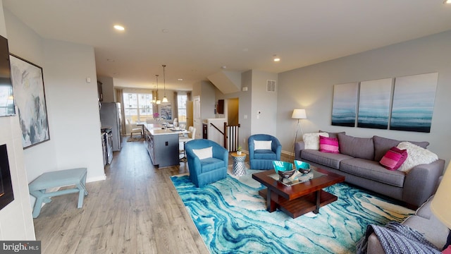 living room with light wood-type flooring and sink