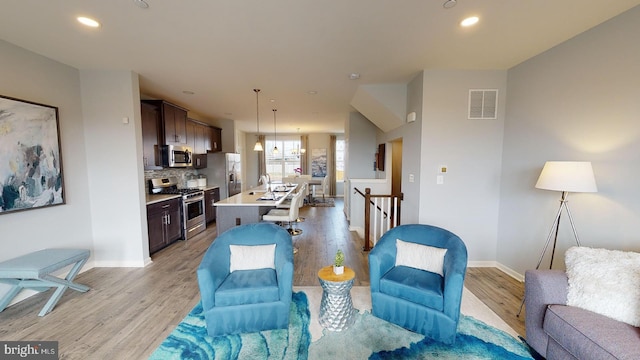 living room featuring light wood-type flooring and sink