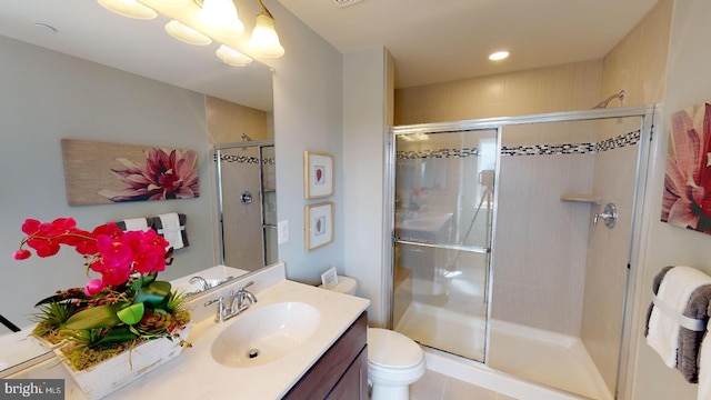 bathroom with tile patterned flooring, vanity, toilet, and walk in shower