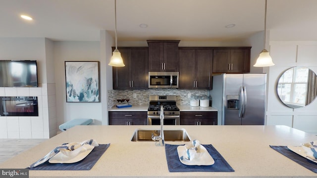 kitchen with light stone countertops, stainless steel appliances, pendant lighting, decorative backsplash, and dark brown cabinets