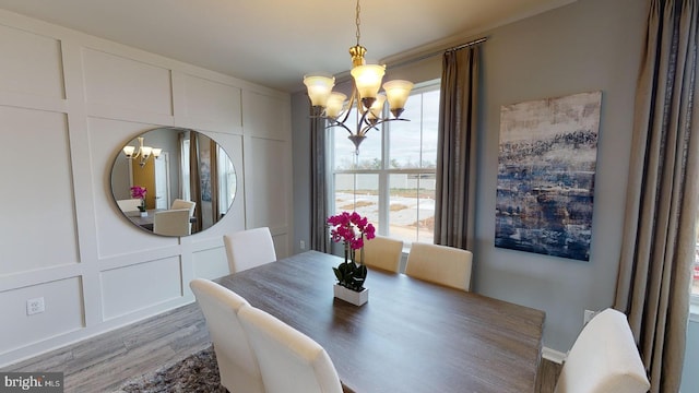 dining area with hardwood / wood-style flooring and a notable chandelier