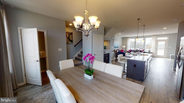 dining area featuring light hardwood / wood-style floors, a notable chandelier, and sink