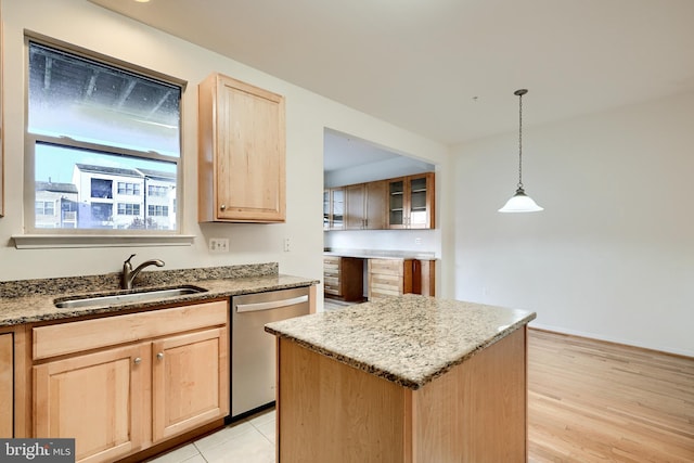 kitchen featuring sink, pendant lighting, dishwasher, light hardwood / wood-style floors, and a kitchen island