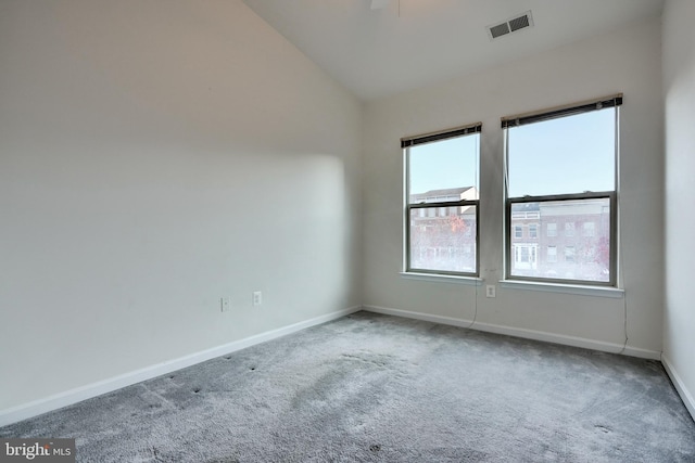 carpeted empty room featuring lofted ceiling