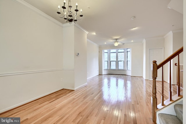 unfurnished living room with ceiling fan with notable chandelier, light hardwood / wood-style floors, and ornamental molding