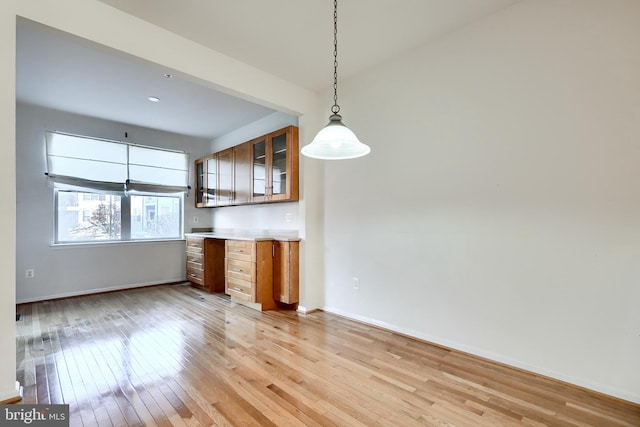 kitchen with decorative light fixtures and light hardwood / wood-style flooring