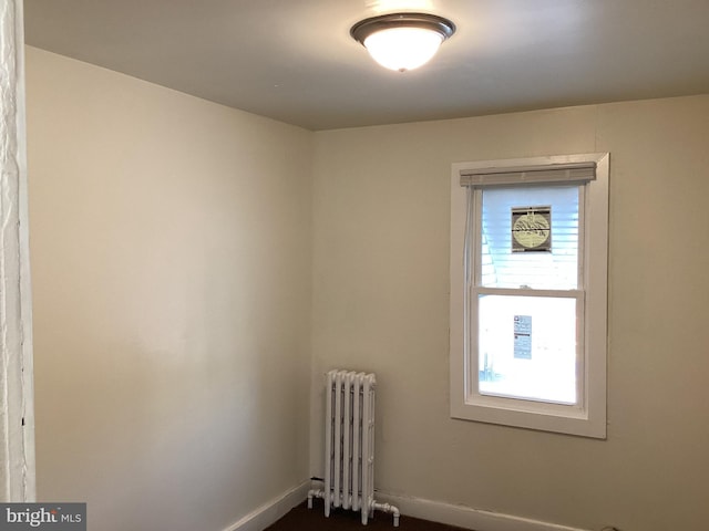 unfurnished room with radiator heating unit