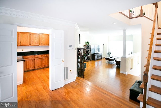 kitchen with ornate columns, light hardwood / wood-style floors, and ornamental molding