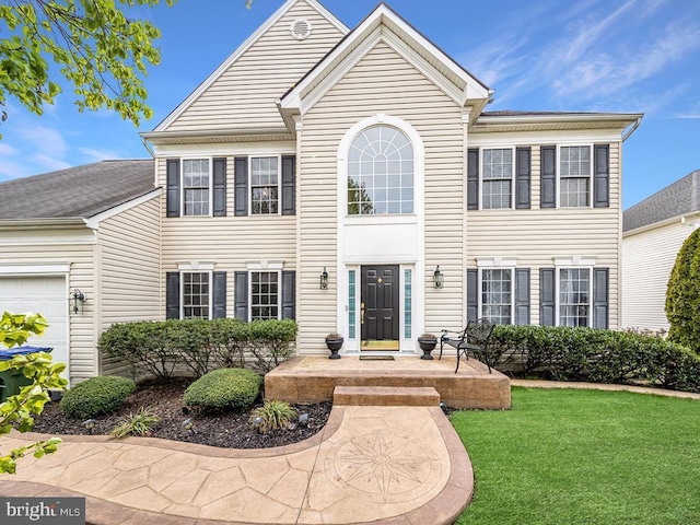 view of front of property featuring a front yard and a garage