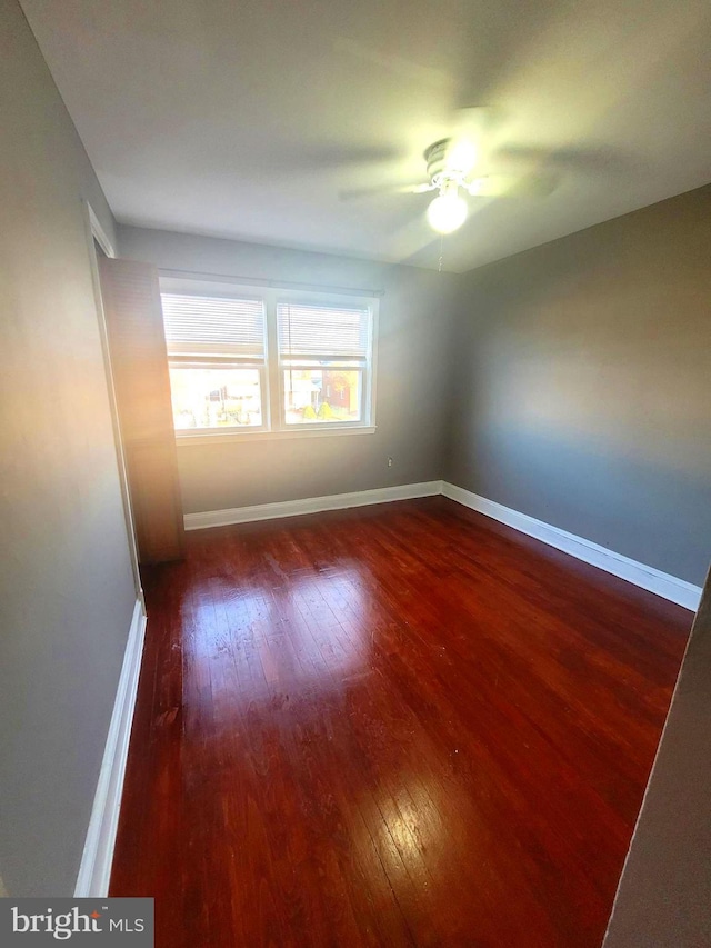 unfurnished room featuring ceiling fan and dark wood-type flooring