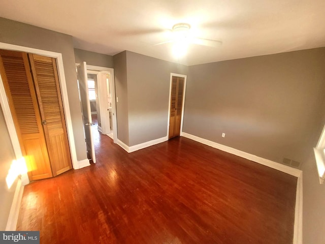 unfurnished bedroom with ceiling fan and dark hardwood / wood-style flooring