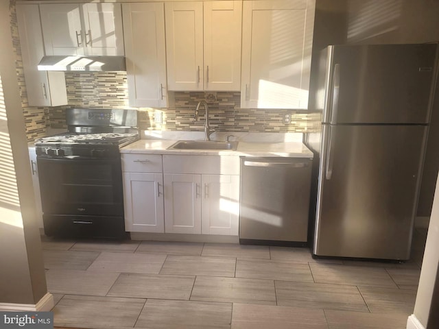 kitchen with white cabinets, decorative backsplash, stainless steel appliances, and sink