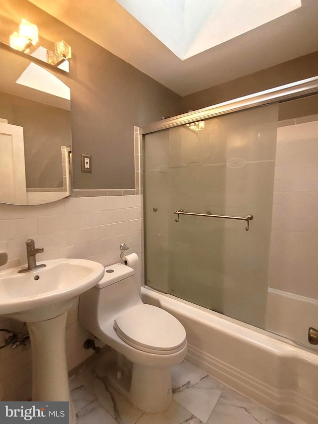 full bathroom with sink, toilet, tile walls, and enclosed tub / shower combo