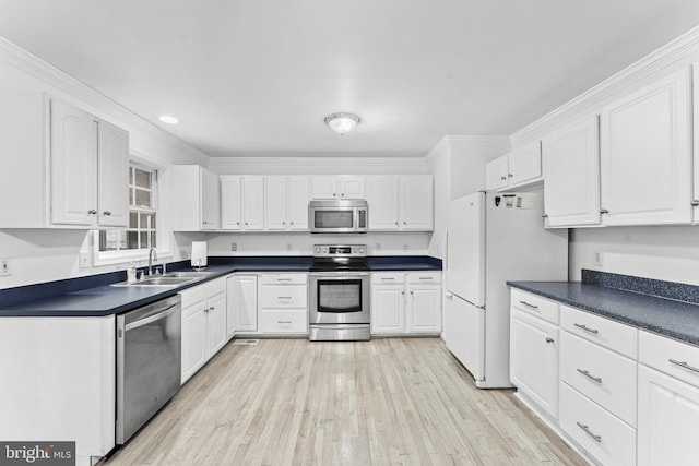 kitchen featuring white cabinets, sink, light wood-type flooring, and stainless steel appliances