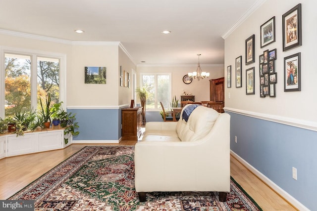 living room featuring crown molding, a healthy amount of sunlight, and a notable chandelier