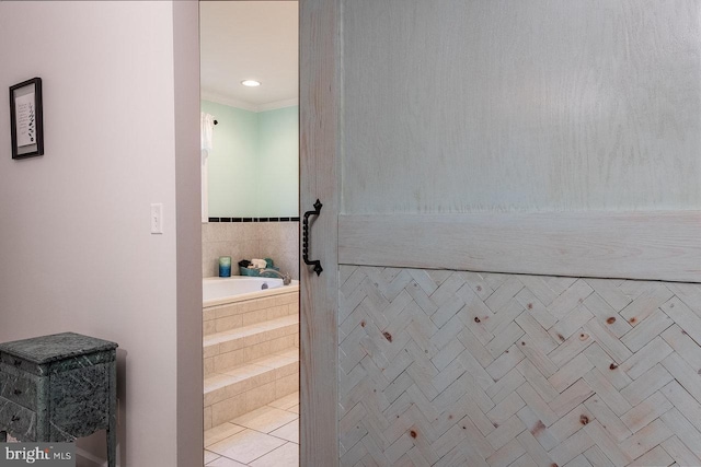 bathroom with tiled bath and tile patterned flooring