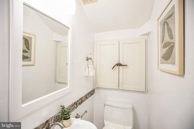 bathroom with toilet and lofted ceiling