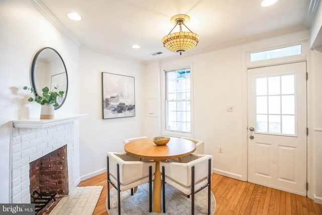 dining area featuring a wealth of natural light, a fireplace, and light hardwood / wood-style floors