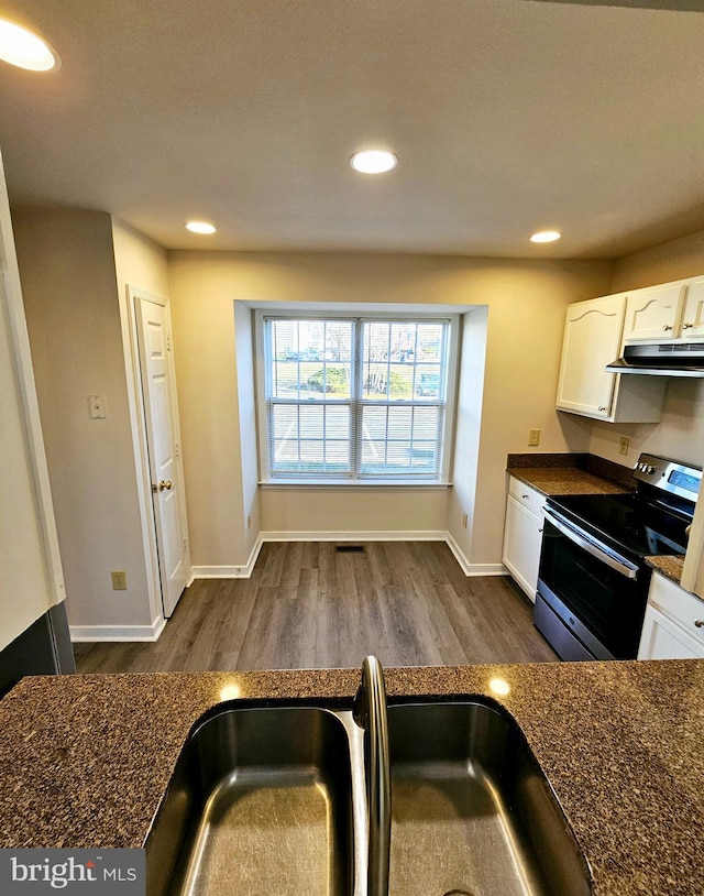 kitchen with stainless steel range with electric cooktop, white cabinets, sink, dark hardwood / wood-style floors, and dark stone countertops