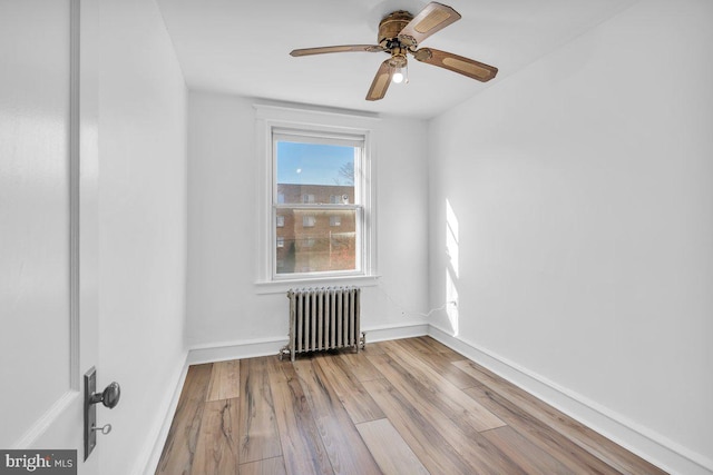 unfurnished room featuring light hardwood / wood-style floors, radiator, and ceiling fan