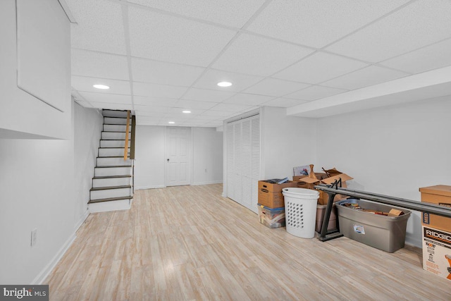 basement with light hardwood / wood-style floors and a drop ceiling