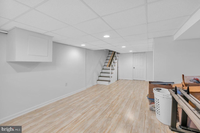 basement with light hardwood / wood-style flooring and a drop ceiling