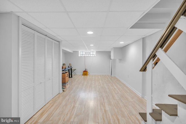 basement featuring light hardwood / wood-style floors and a drop ceiling