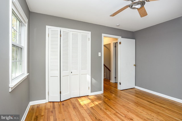 unfurnished bedroom featuring a closet, ceiling fan, and light hardwood / wood-style flooring