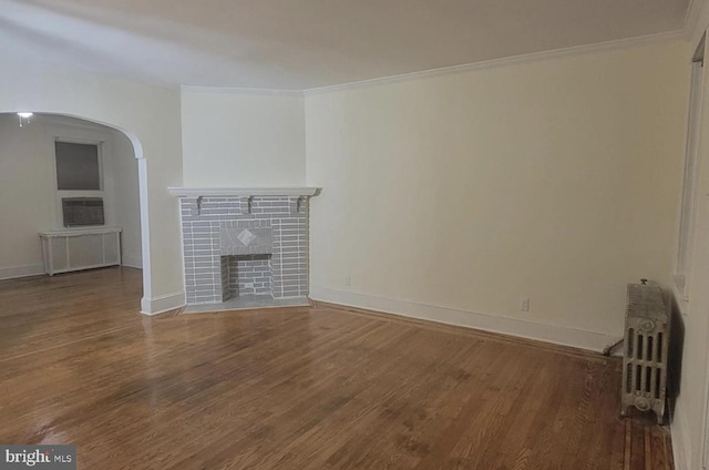 unfurnished living room featuring hardwood / wood-style flooring, ornamental molding, and radiator