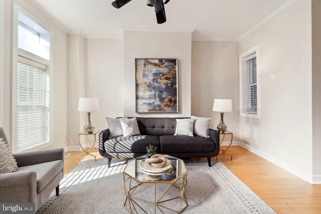 living room with ceiling fan, light wood-type flooring, and ornamental molding