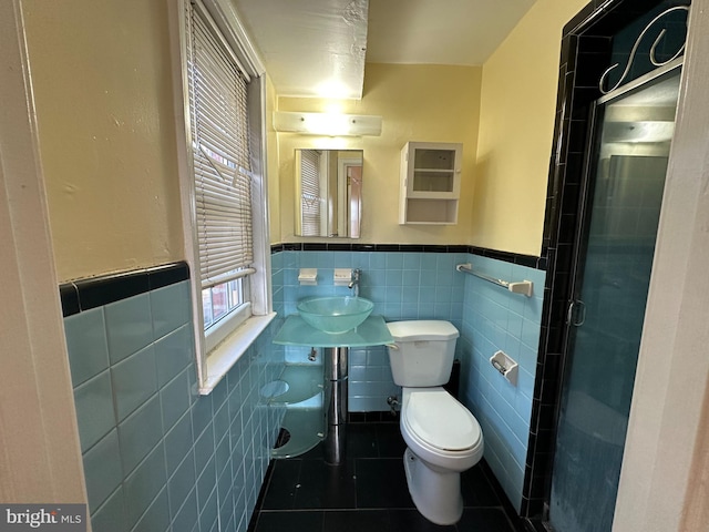 bathroom featuring tile patterned flooring, sink, an enclosed shower, and tile walls