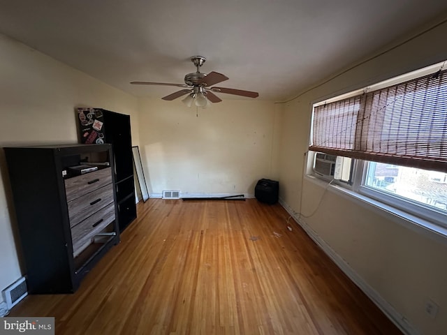 interior space featuring ceiling fan, cooling unit, and wood-type flooring