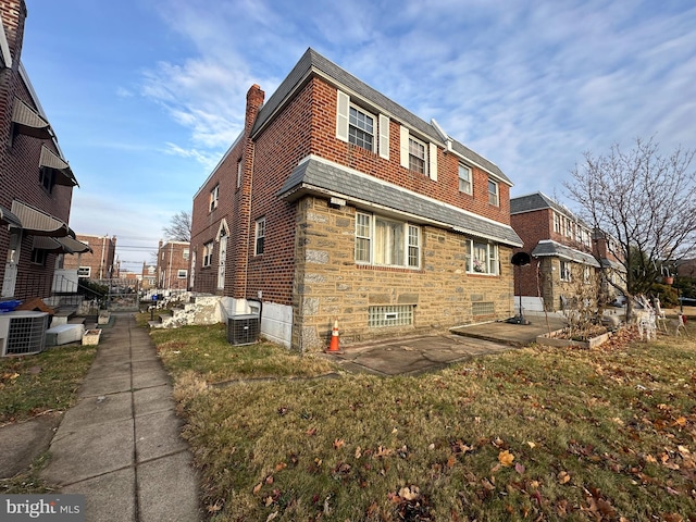 view of property exterior featuring a lawn and central AC unit