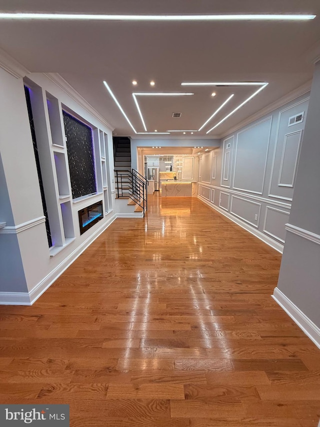 interior space with hardwood / wood-style floors and ornamental molding