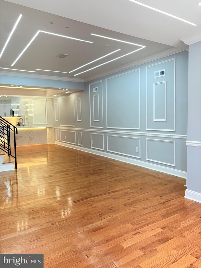 5111 Warrington Ave, Philadelphia, PA 19143 - unfurnished room featuring ornamental molding, a decorative wall, wood finished floors, and baseboards