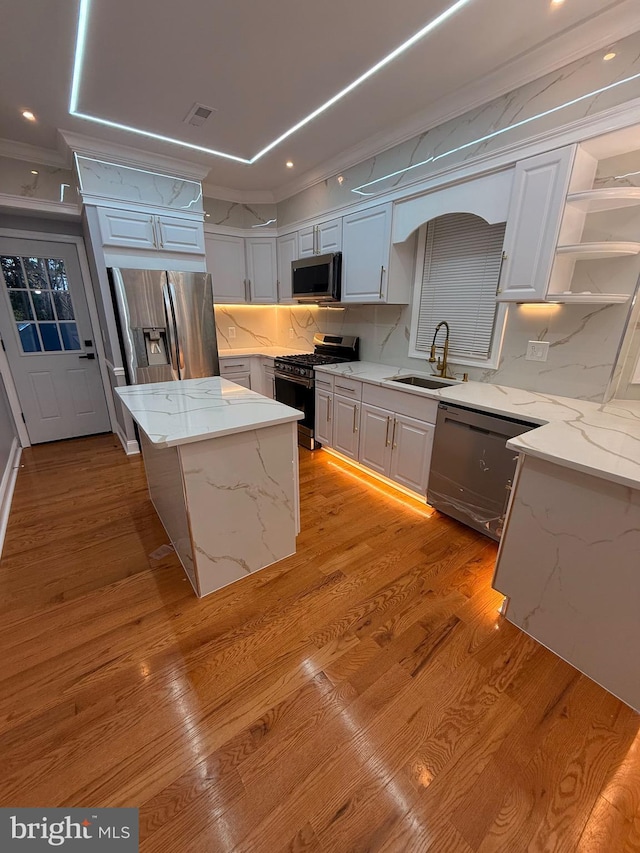 5111 Warrington Ave, Philadelphia, PA 19143 - kitchen with appliances with stainless steel finishes, a kitchen island, open shelves, light wood-style floors, and tasteful backsplash