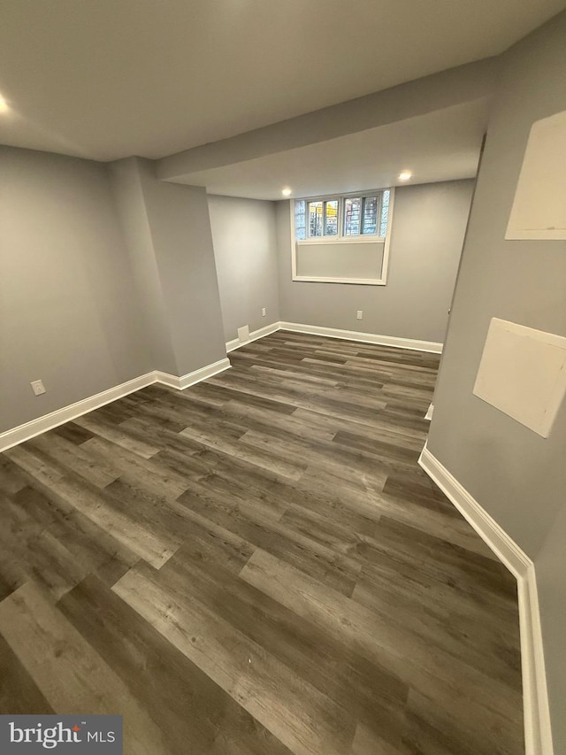 basement with dark hardwood / wood-style floors