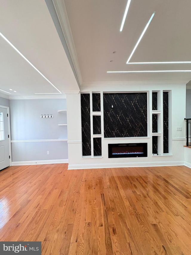 5111 Warrington Ave, Philadelphia, PA 19143 - unfurnished living room with crown molding, built in features, a glass covered fireplace, wood finished floors, and baseboards