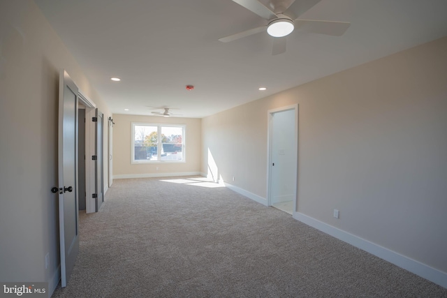 carpeted spare room with ceiling fan