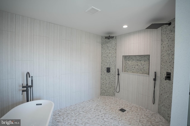 bathroom with tile walls and shower with separate bathtub