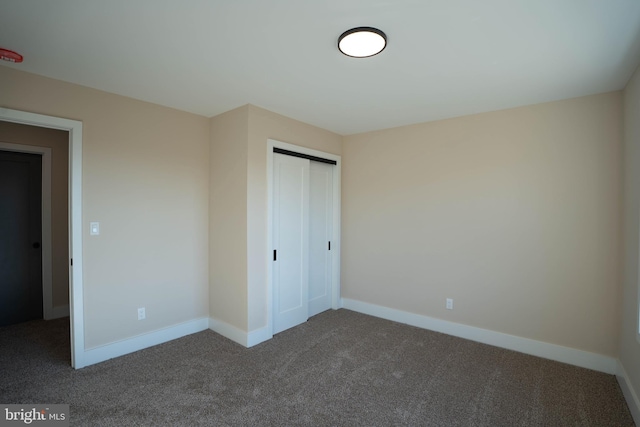 unfurnished bedroom featuring carpet flooring and a closet