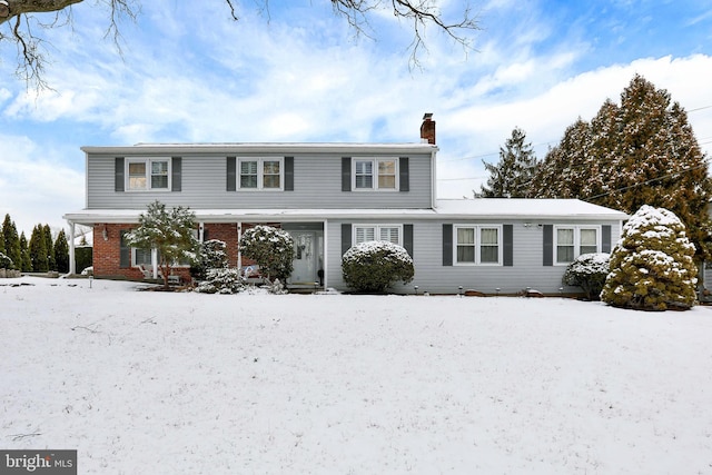 view of front of house with brick siding and a chimney