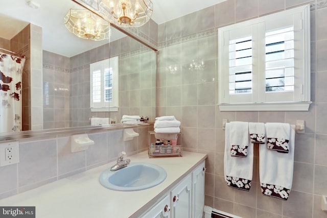 bathroom with a shower with curtain, a notable chandelier, tile walls, and vanity